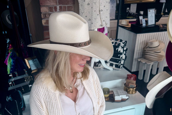A straw cowboy hat with a cattleman crease, tried on in the Moon Ridge shop