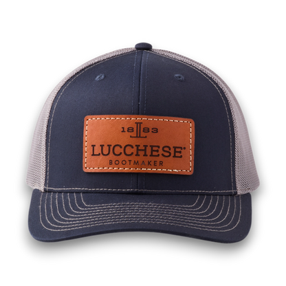 Moon Ridge Hats and Heritage Lucchese navy and charcoal trucker cap with a brown leather logo patch and mesh back