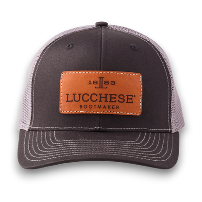 Moon Ridge Hats and Heritage Lucchese black and charcoal mesh trucker cap with a tan leather logo patch