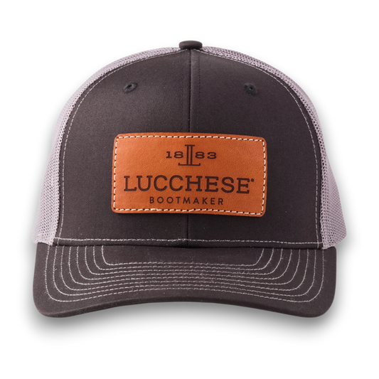 Moon Ridge Hats and Heritage Lucchese black and charcoal mesh trucker cap with a tan leather logo patch