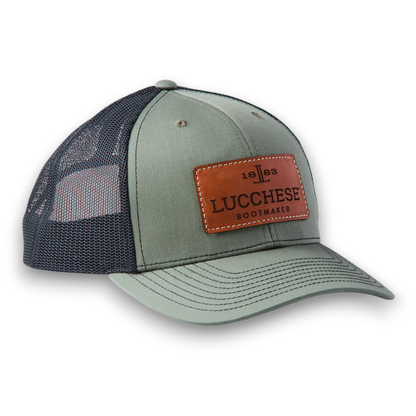 Moon Ridge Hats and Heritage Lucchese loden and black trucker cap with a brown leather logo patch and mesh back
