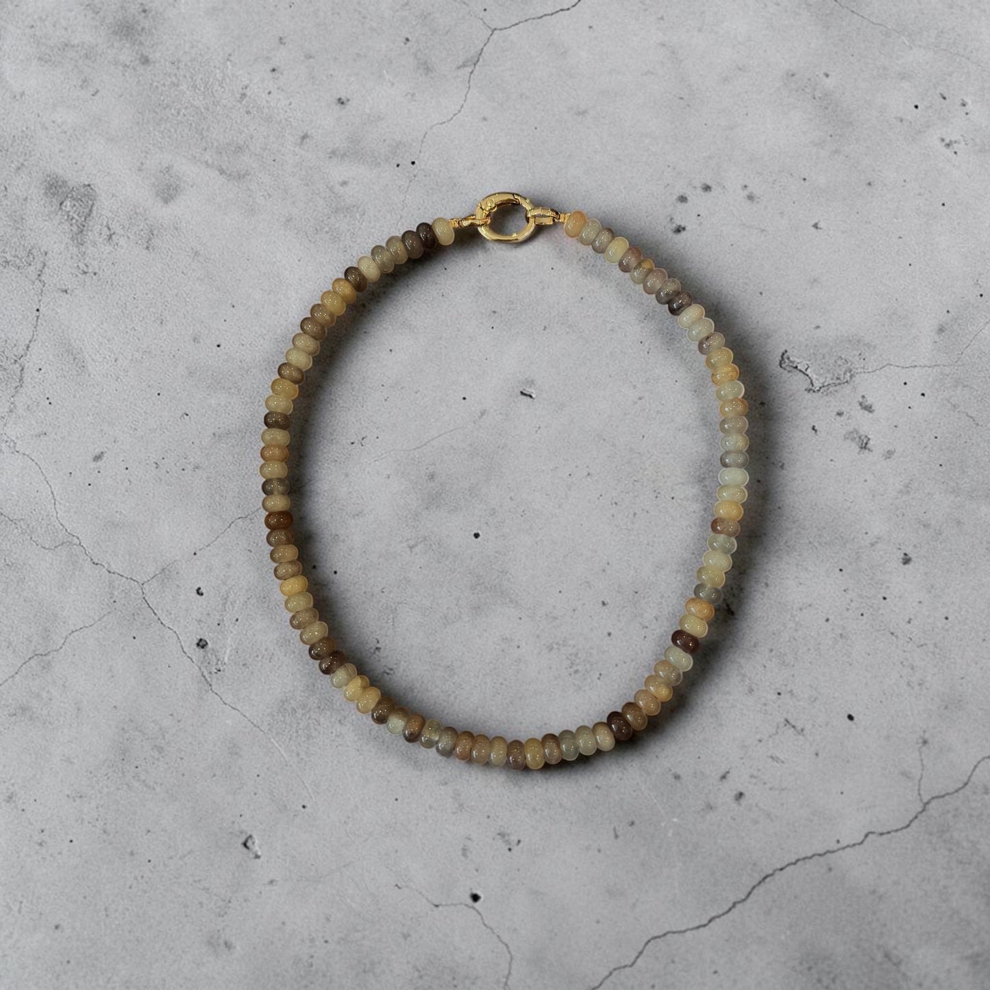 Moon Ridge Hats and Heritage Sahara Beaded Necklace with gold clasp and natural stone beads in earthy tones.