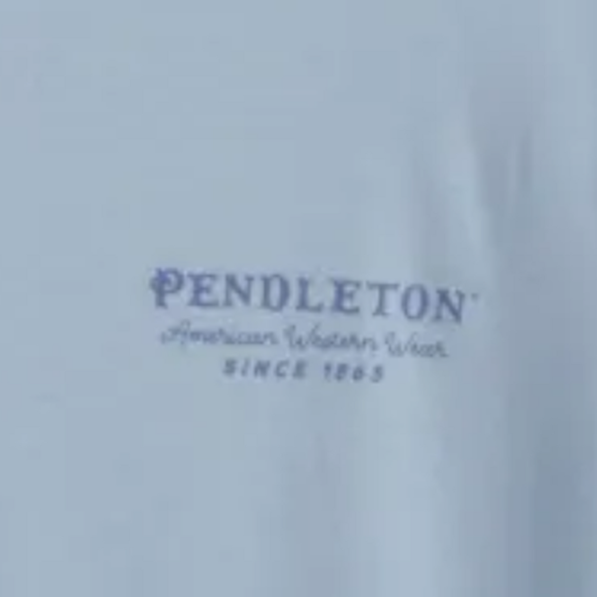 Pendleton American Western Wear left-chest logo close-up on light blue tee