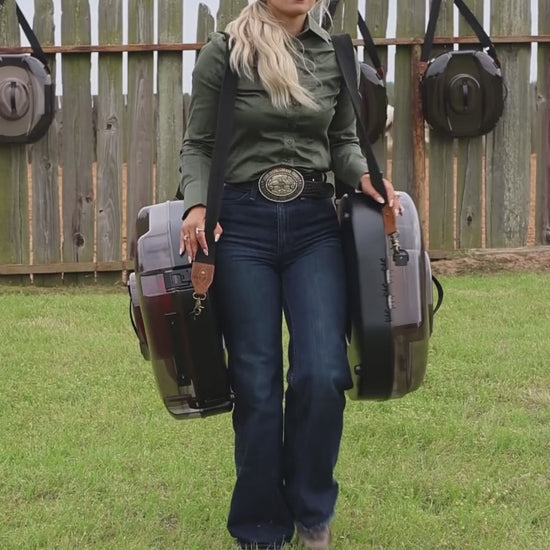 Woman carrying two A Better Hat Can cowboy hat cases by the shoulder strap and top handle