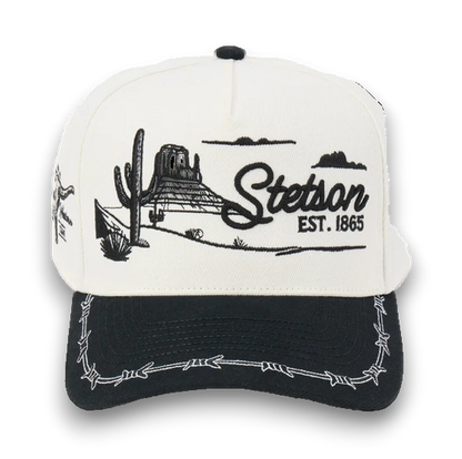 Rafter M Hat Company Stetson trucker hat with embroidered desert landscape, cacti, mesas, and barbed wire brim. White and black.